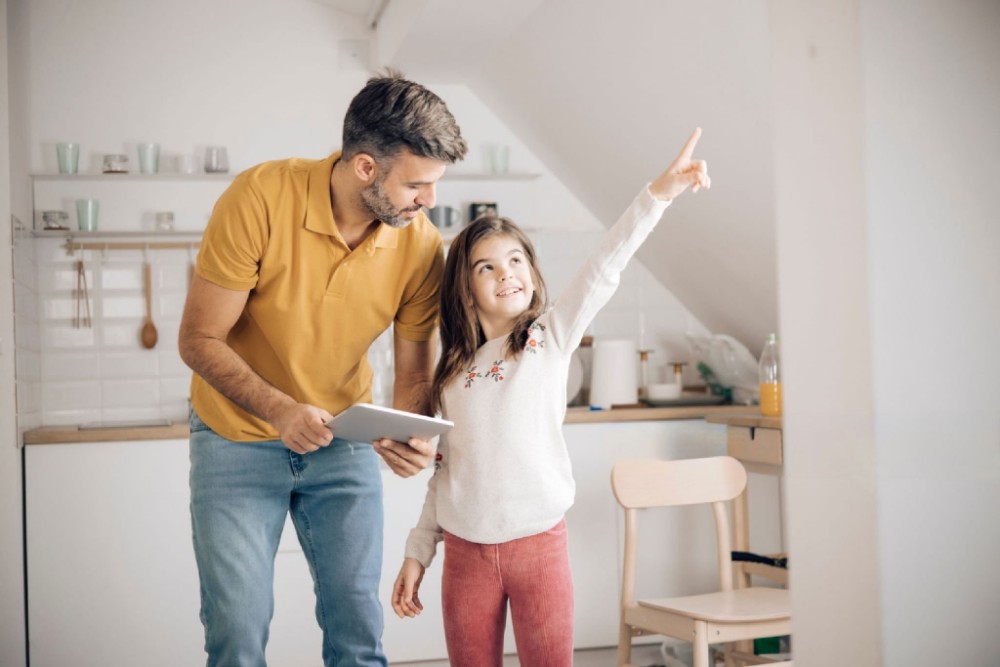 little girl and her dad using a digital tablet